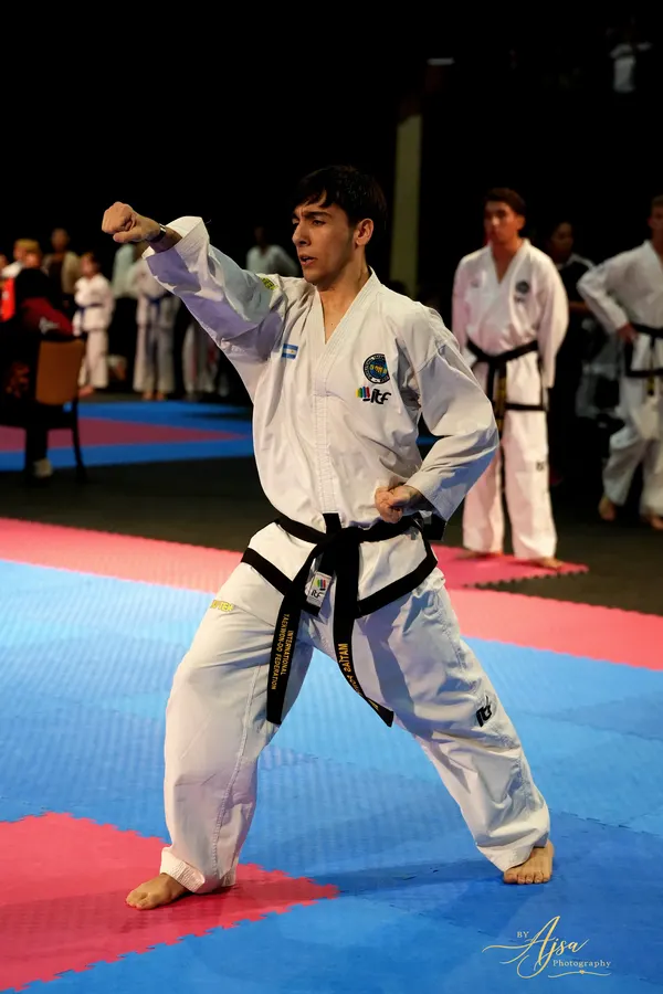 Black belt performing a pattern on the red and blue mat