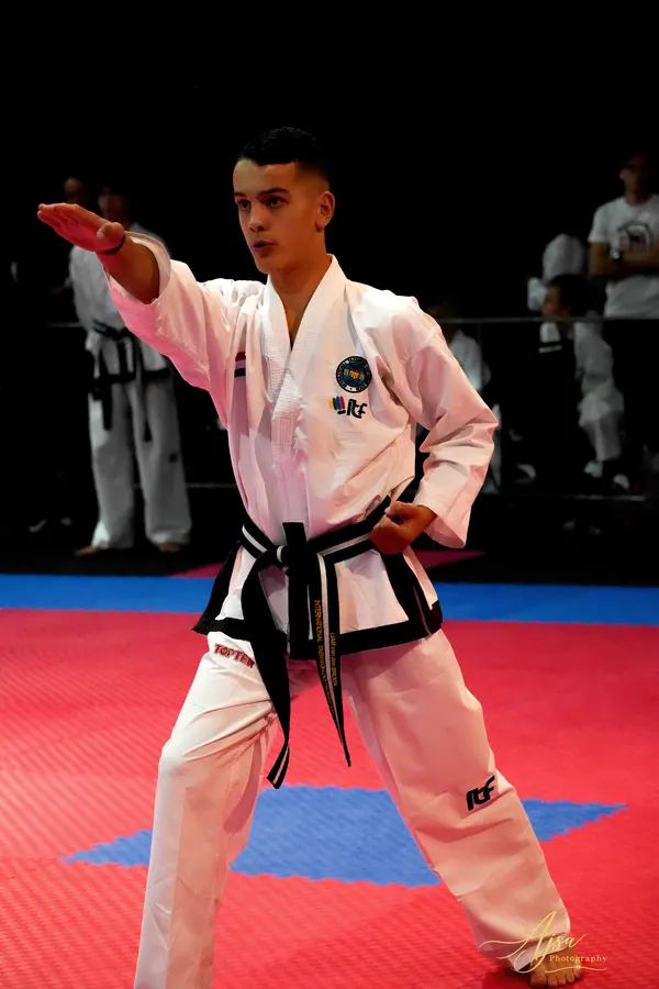 Athlete holding a stance with an extended arm during a pattern