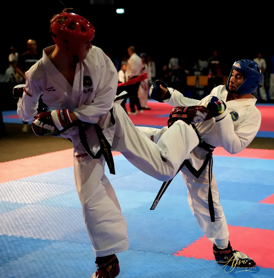 Competitors exchanging kicks on the blue mat