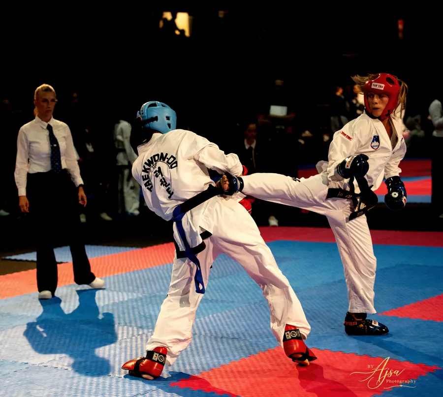Competitor delivering a side kick with a referee watching